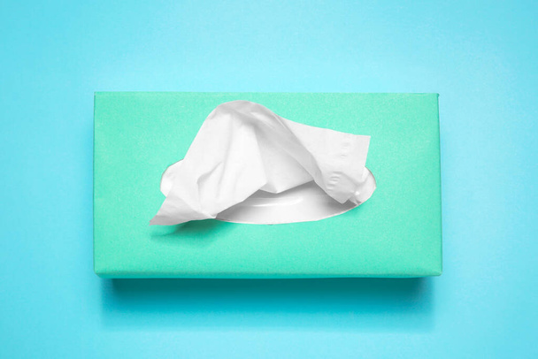 Box with paper tissues on light blue background, top view - Valokuva, kuva