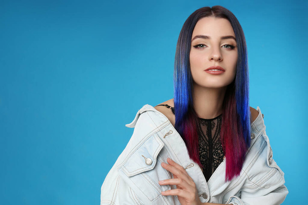 Young woman with bright dyed hair on blue background, space for text - Foto, Imagem