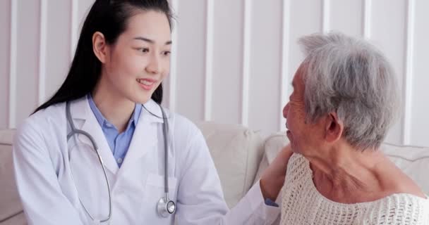 Female doctor visiting senior woman at home. Female doctor help patient at checkup medical consultation at home. elderly grandma listen caregiver giving support. healthcare and medical concept - Footage, Video