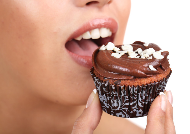 Closeup of woman eating chocolate cupcake - 写真・画像