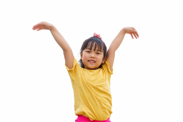 Маленькая девочка улыбается в жесте, чтобы летать на белом фоне. Активный отдых и открытый спорт для детей
. - Фото, изображение
