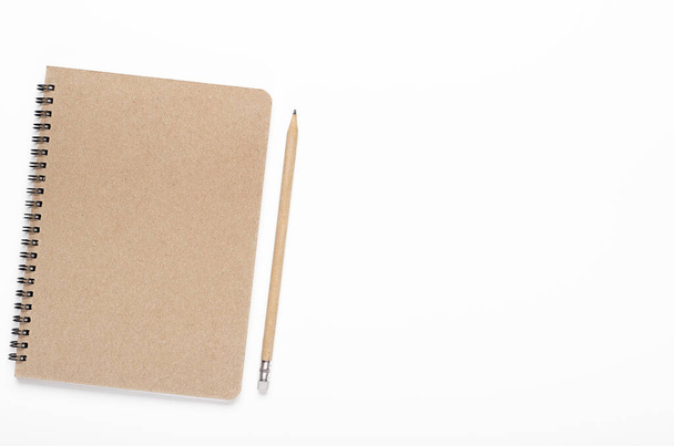 Notebook on kierre kraft paperia lyijykynällä valkoisella taustalla. Toimistopöytä, paperitavarat. Kopioi tilaa, ylhäältä, tasainen lay - Valokuva, kuva