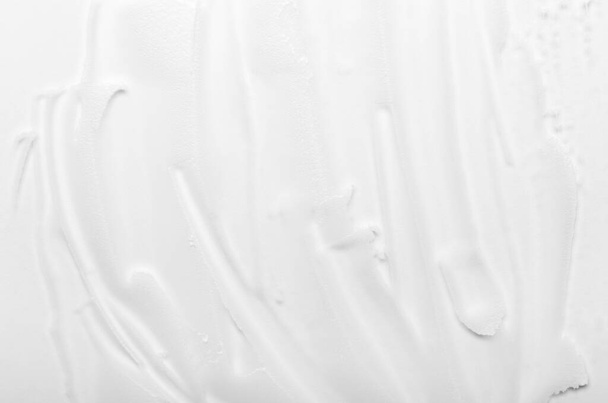 Textura de crema facial blanca untada sobre un fondo blanco. Textura cosmética, cuidado facial y corporal
 - Foto, Imagen