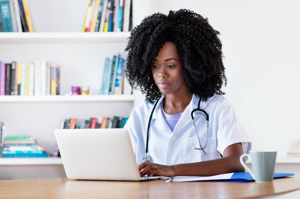 Researching african american medical female student at computer at hospital - Foto, Imagen
