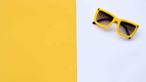 Modern fashionable sunglasses on white and yellow background - Photo, image
