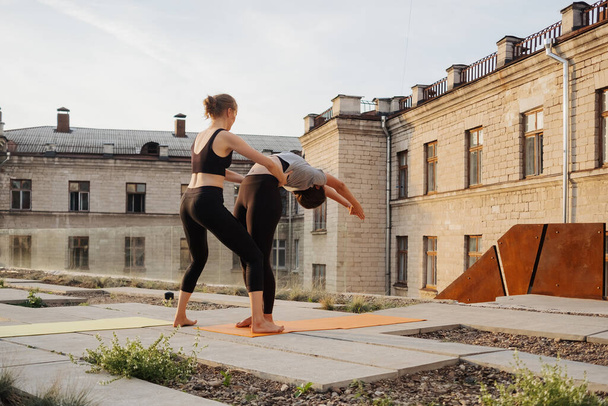Due giovani ragazze che praticano stretching e yoga esercizio di allenamento insieme - Foto, immagini