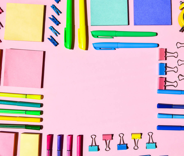 ピンクの背景に異なるオフィスや学校用品。テキスト、鉛筆紙クリップステッカーマーカーと服ピンのためのコピースペース - 写真・画像