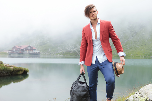 Modemann mit Hut und Reisetasche am See - Foto, Bild