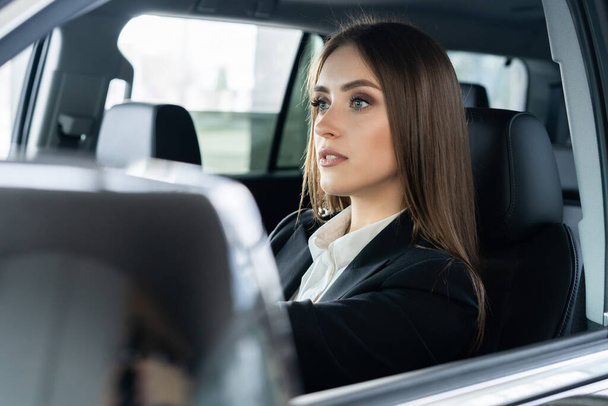Beautiful young business woman driving a car. - Foto, Bild