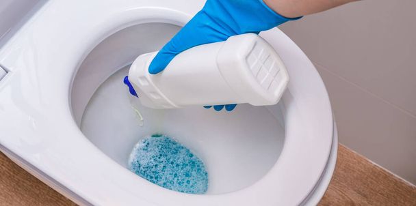 Clean toilet with cleaning agent bleaching gel and hand in. The concept of the home cleaning, cleaning service - Foto, immagini