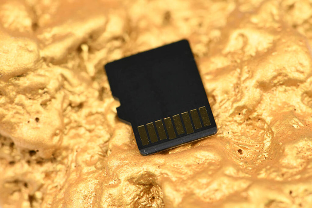 Cartão de memória SD isolado em fundo dourado. Foco suave
 - Foto, Imagem