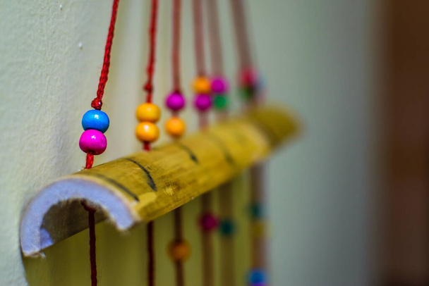 A multicolored spherical objects being hanged from red ropes . A toy for babies - Photo, Image