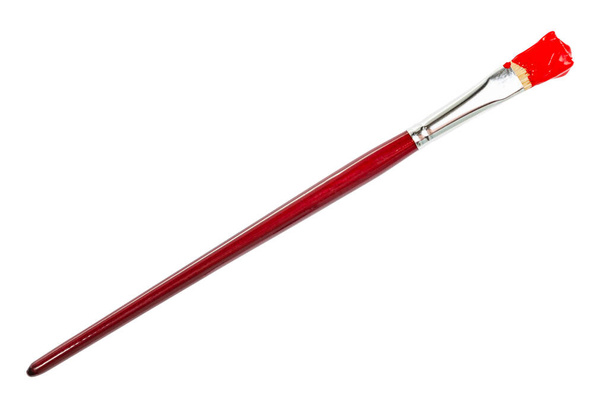 Flachpinsel mit rot gefärbter Spitze im Fleck und braunem Griff isoliert auf weißem Hintergrund - Foto, Bild