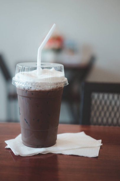 Délicieux café froid rafraîchissant moka mélange garniture de chocolat noir avec mousse de lait mis sur papier de soie - Photo, image