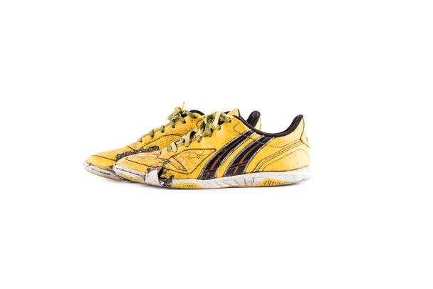 Viejo desgastado zapatos deportivos futsal amarillo sucio sobre fondo blanco fútbol artículos de deporte objeto aislado
 - Foto, imagen