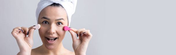 Beauty portrait of woman in white towel on head with a sponge for a body in view of a pink heart. Skincare cleansing eco organic cosmetic spa relax concept. - Photo, Image