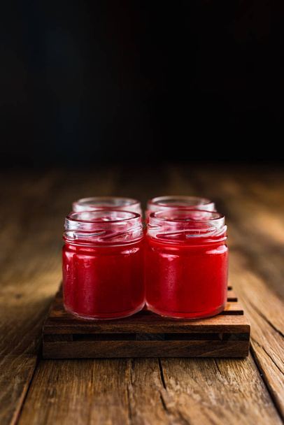 Red colored alcoholic shooters, or shot drinks on wooden table, with copy space - Foto, imagen