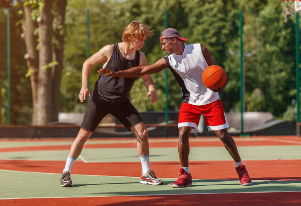 Jugadores profesionales de baloncesto en cancha al aire libre durante juego amistoso
 - Foto, Imagen