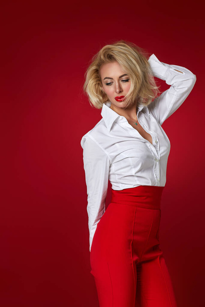 mulher loira em camisa branca e calças vermelhas
 - Foto, Imagem