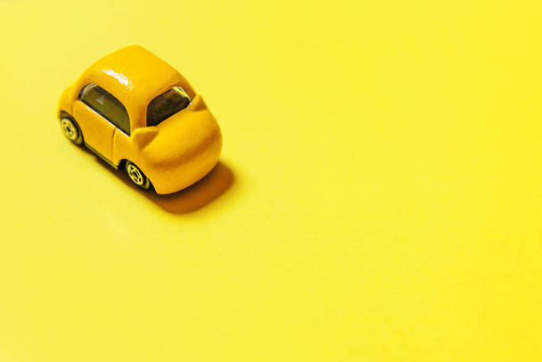 Simply design yellow vintage retro toy car isolated on yellow colorful background. Automobile and transportation symbol. City traffic delivery concept. Copy space - Photo, Image