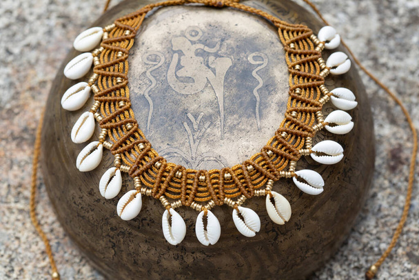 Collar boho Macrame con conchas blancas sobre fondo de metal vintage
 - Foto, imagen