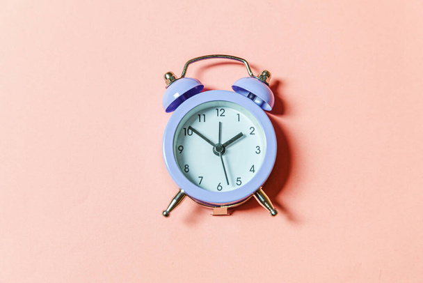 Simply minimal design ringing twin bell vintage classic alarm clock Isolated on pink pastel background. Rest hours time of life good morning night wake up awake concept. Flat lay top view copy space - Foto, Imagen