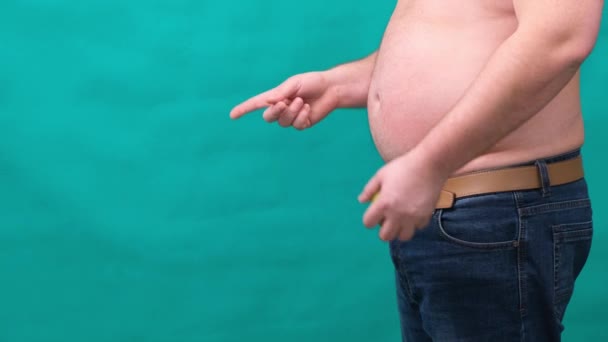 dikke man met een dikke buik houdt een groene appel in zijn hand. Het concept van gezond eten en afvallen, dieet. - Video