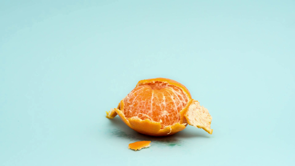 Zastavit animaci pohybu celé a oloupané mandarinky na modré - Záběry, video