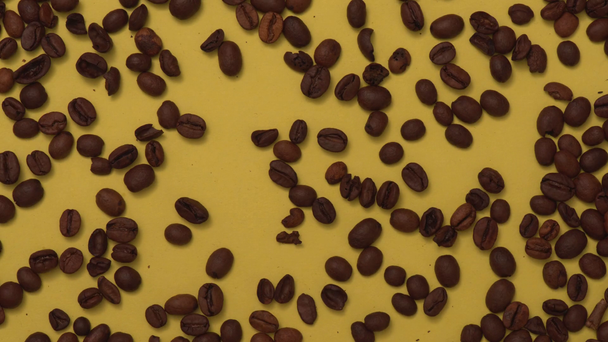 Stop motion animation of organic coffee beans on yellow - Imágenes, Vídeo