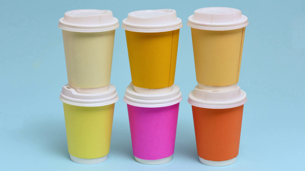 Stop motion animation of colorful paper cups on blue - Footage, Video