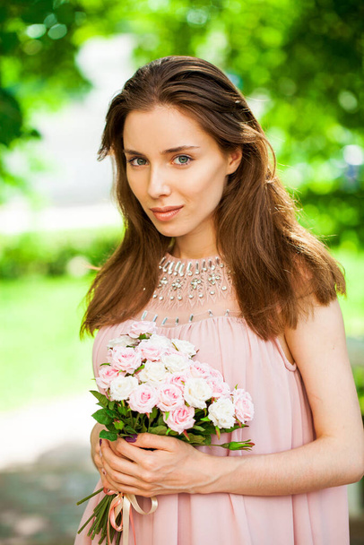 Close up portrait of a young brunette woman in pink dress - 写真・画像