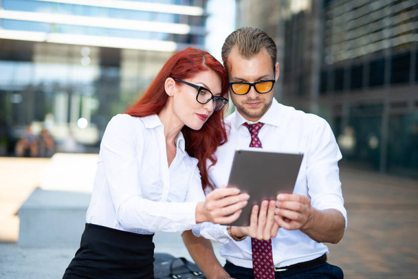 Businessman and businesswoman using a tablet together, business teamwork and technology concept - Foto, afbeelding