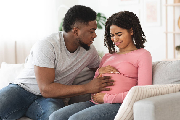 Tarkkaavainen aviomies tukee raskaana olevaa vaimoaan tuskissaan - Valokuva, kuva