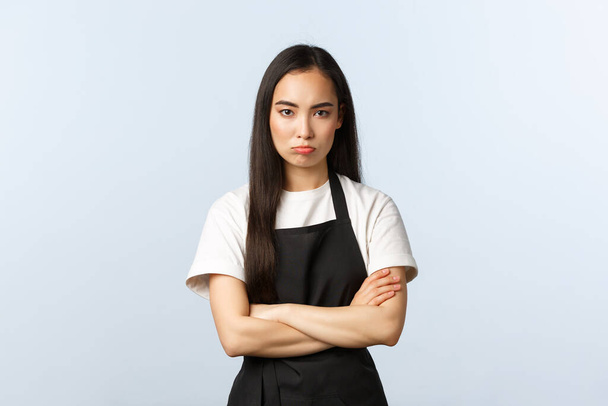 Kavárna, malý byznys a startup koncept. Smutný uražený roztomilý asijský žena zaměstnanec v kavárně, barista nebo servírka pracovní restaurace, stánek uzavřený póza se zkříženýma rukama, trucování, naštvaný na vás - Fotografie, Obrázek