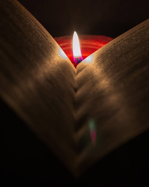 Reading a book by candlelight - Foto, Bild
