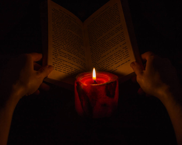 Reading a book by candlelight - Foto, imagen