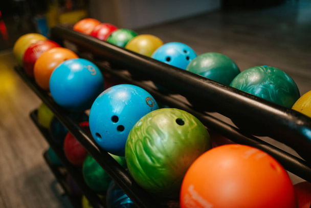 Різнокольорові кульки для боулінгу на полиці в клубі боулінгу
 - Фото, зображення