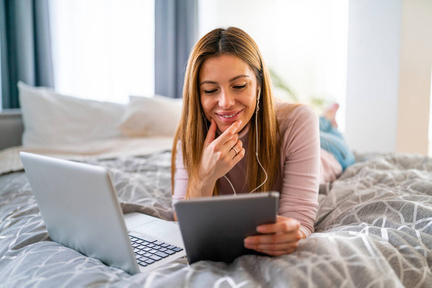 Ευτυχισμένη γυναίκα που χρησιμοποιεί φορητό υπολογιστή, tablet, υπολογιστή στο σπίτι. Τεχνολογία, άνθρωποι έννοια - Φωτογραφία, εικόνα