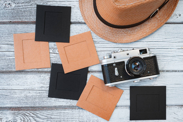 Leg platte witte houten achtergrond, vintage zomer accessoires, vintage film camera, opslaan van herinneringen aan de zomer. Afbeeldingen in frames - Foto, afbeelding