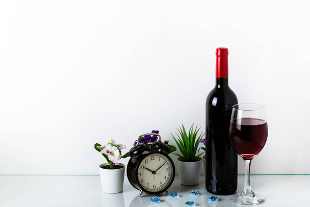 Alarm Clock, green houseplant, red wine and coffe on a white background. The concept of a healthy lifestyle, sport, diet. The concept of time is precious. Home decor with copy space for your text. - Photo, Image