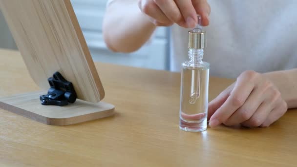 Woman applying serum essense oil to her skin close up - Filmati, video