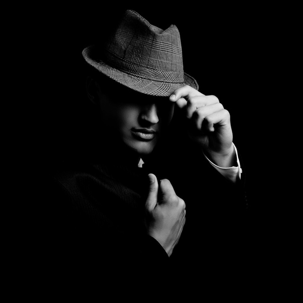 low key portrait of young gangster with hat in the darkness. - Fotó, kép