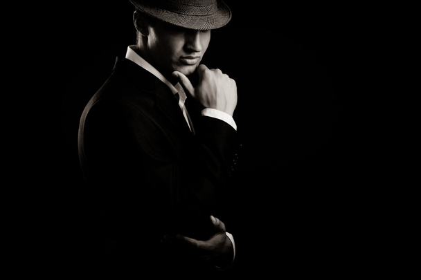 low key portrait of young gangster with hat in the darkness. - Фото, зображення