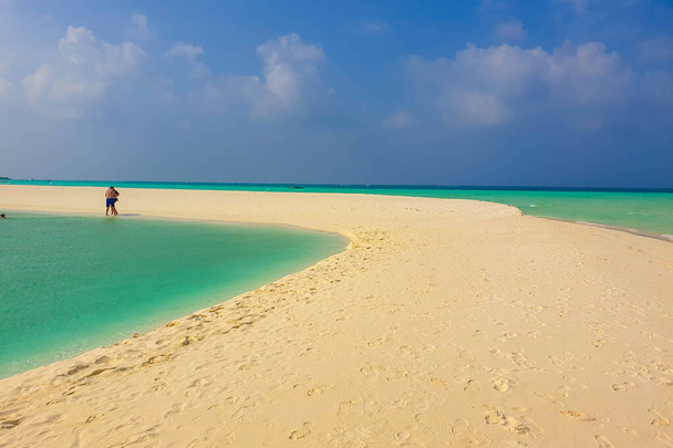 Slunečná pláž s bílým pískem, kokosovými palmami a tyrkysovým mořem. Letní dovolená a koncept tropické pláže. Overwater v letovisku Maldive Island. - Fotografie, Obrázek