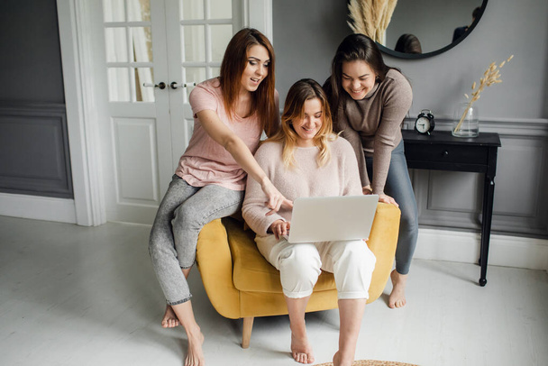 a group of girlfriends communicate with a friend via a video conference on a laptop. Friendship - Fotografie, Obrázek