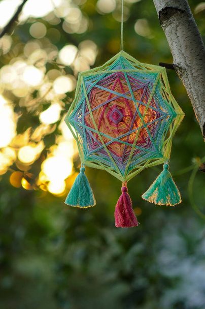 Buntes handgewebtes Garn-Mandala im Freien bei Sonnenuntergang - Foto, Bild