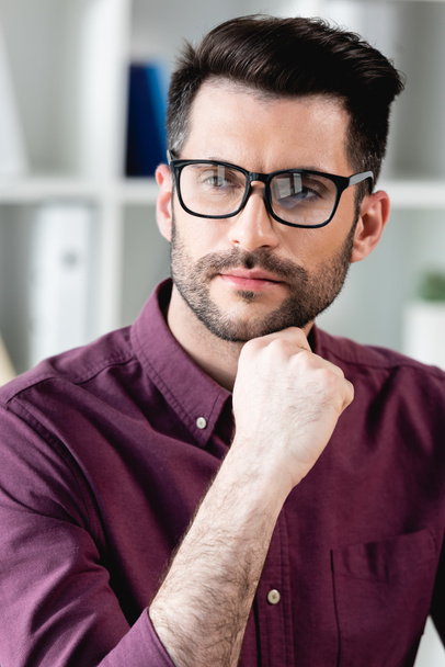 handsome, thoughtful businessman in eyeglasses holding hand near chin while looking away - Photo, Image