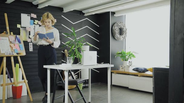 Kobieta czytanie książki w kreatywnym miejscu pracy - Zdjęcie, obraz