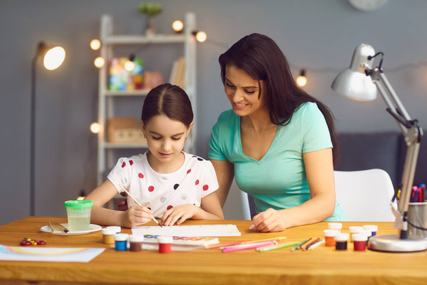 Creativity and development of the child. Happy family mother and daughter draw paints at the table at home. - Foto, Imagem