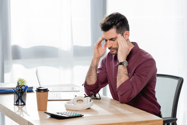 väsynyt liikemies koskettaa päätä kärsiessään migreenistä suljetuin silmin  - Valokuva, kuva